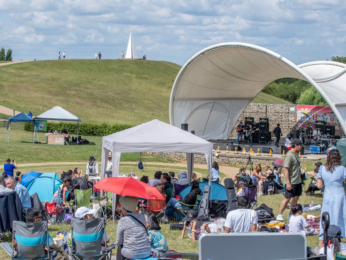 people sat on the grass at the Campbell Park Amphitheatre for the Filipino festival 