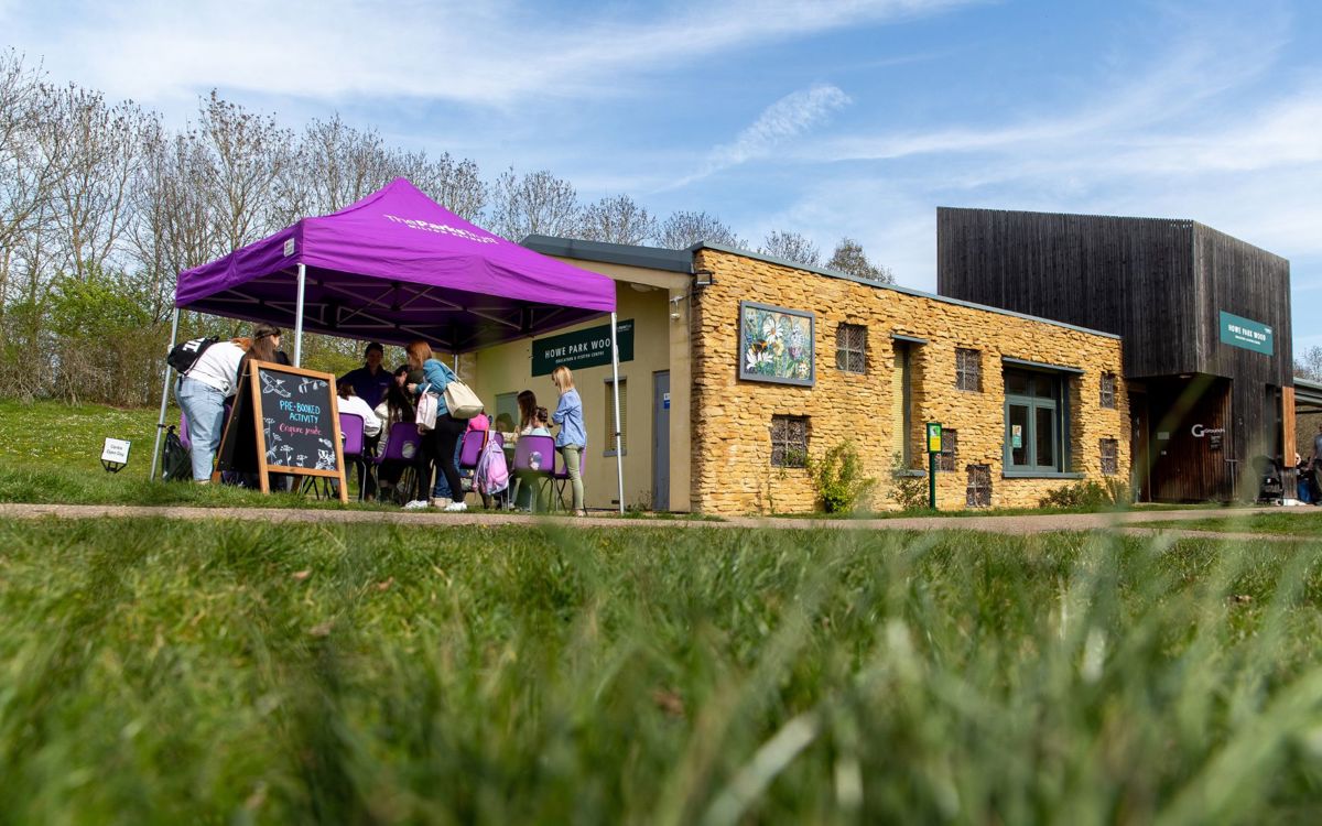 The education centre at Howe Park Wood, with people taking part in outdoor nature activities