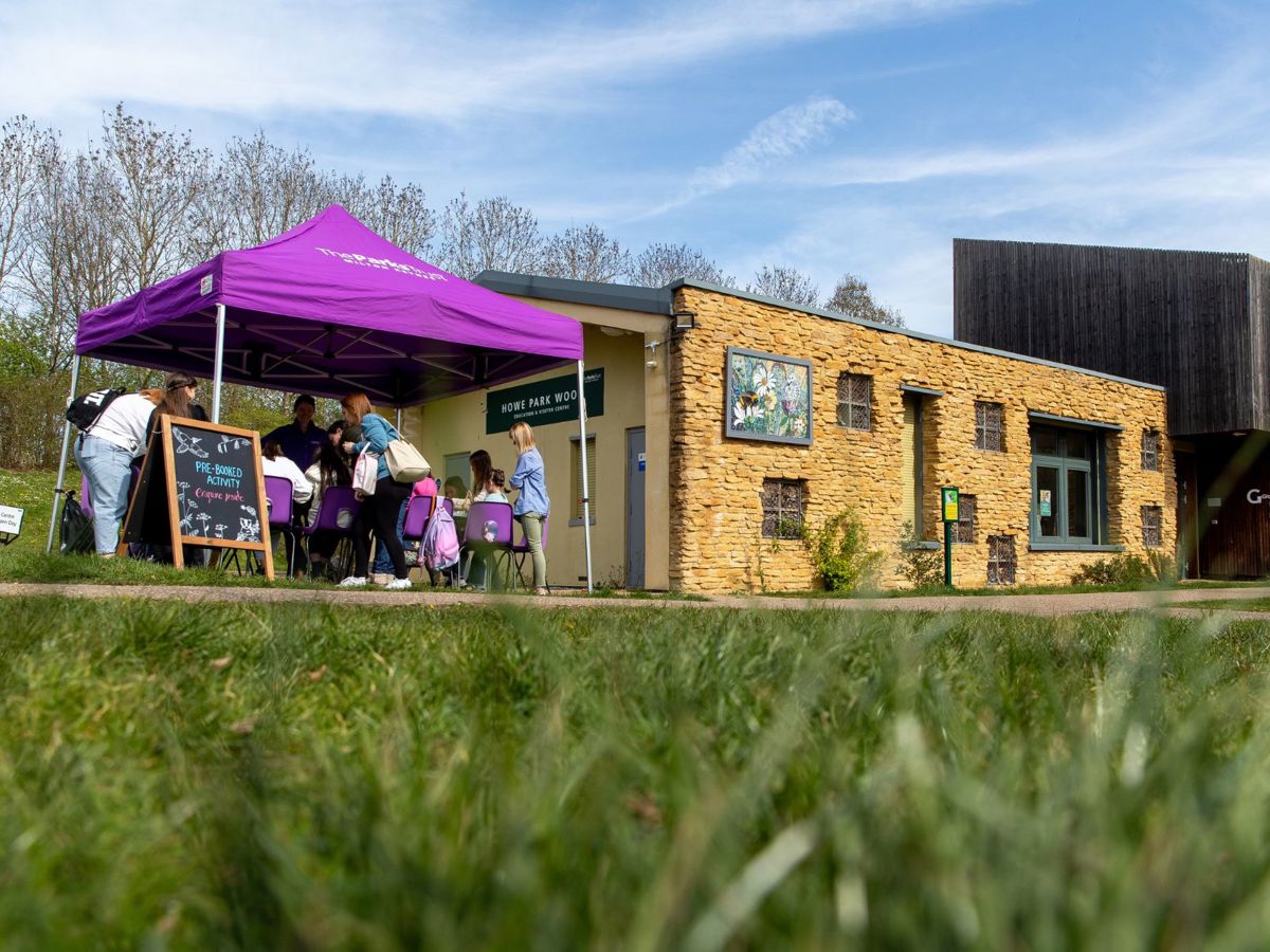 The education centre at Howe Park Wood, with people taking part in outdoor nature activities
