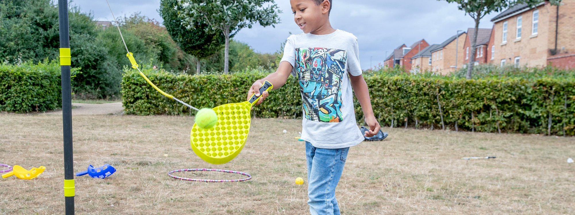 Young child playing swing ball in a park