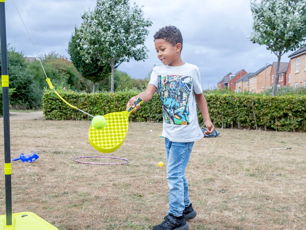 Young child playing swing ball in a park