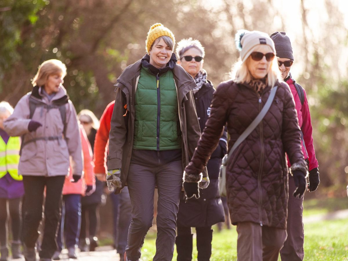 Women in jackets and hats walking in the park