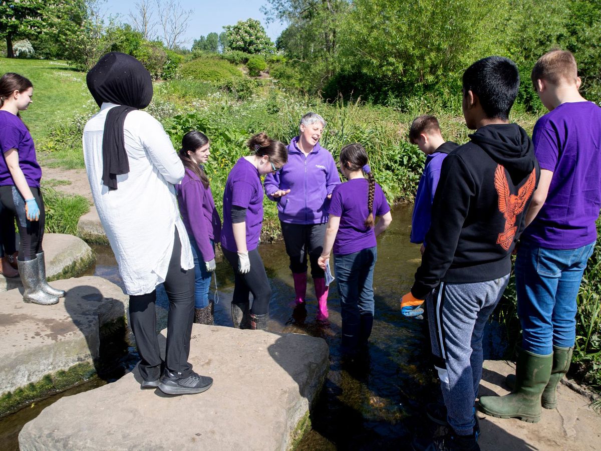 Youth group for teenagers stood next to river