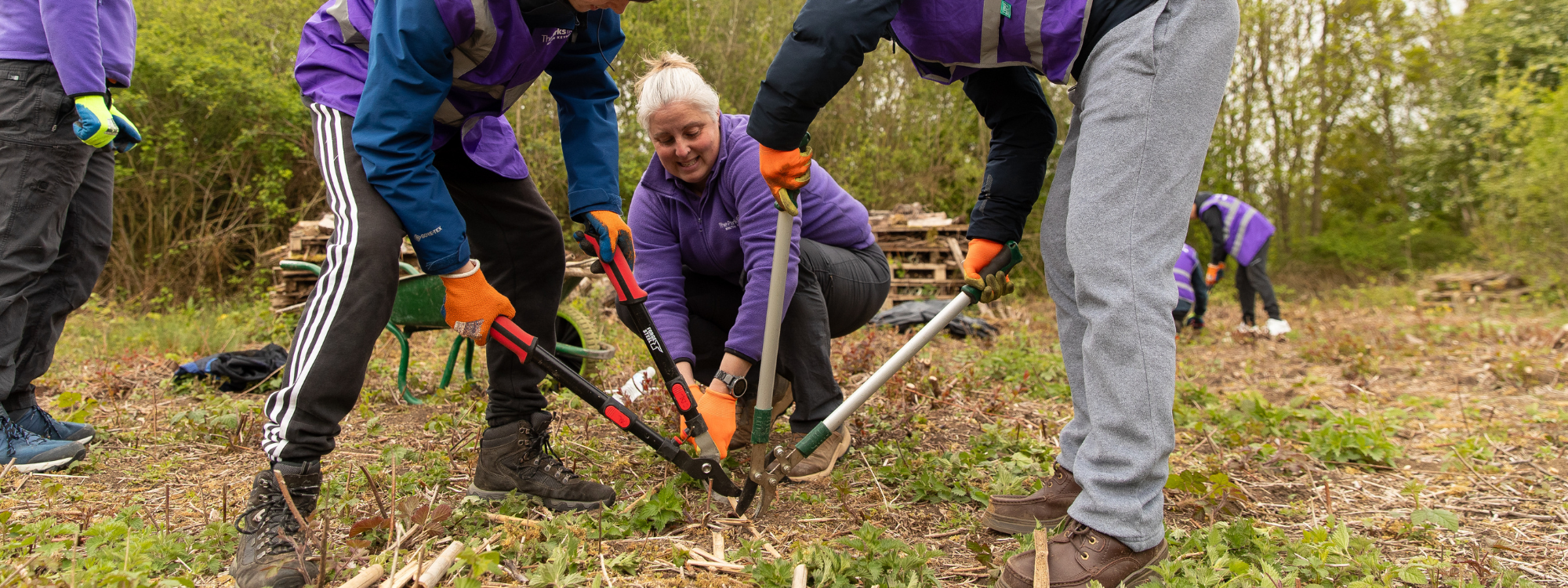 Young people using loppers to cut wood 