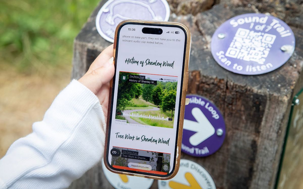 Hand holding phone on Sound Trail webpage on The Parks Trust website