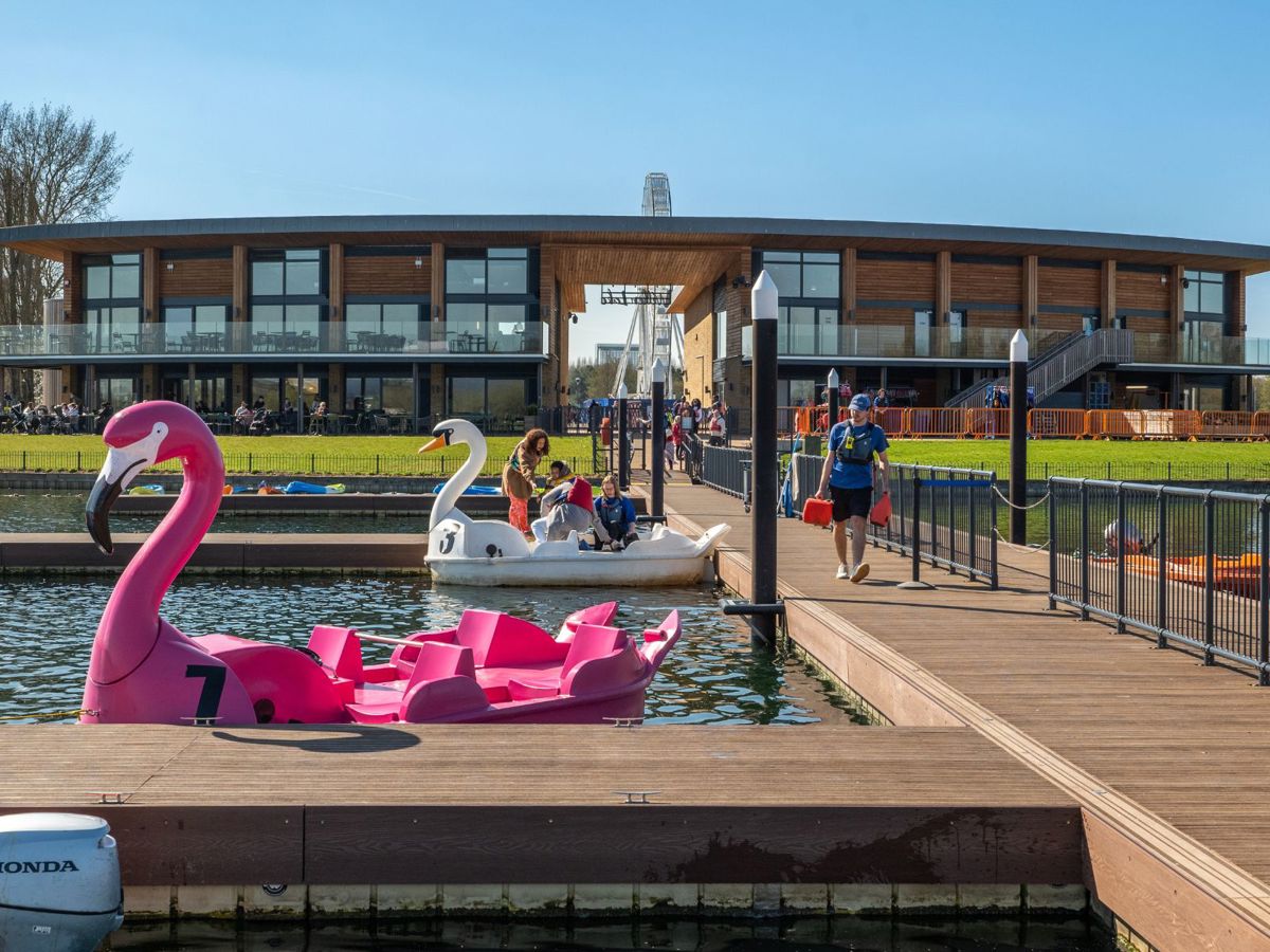 People getting on a pedalo in front of Willen Lake's Watersports Centre