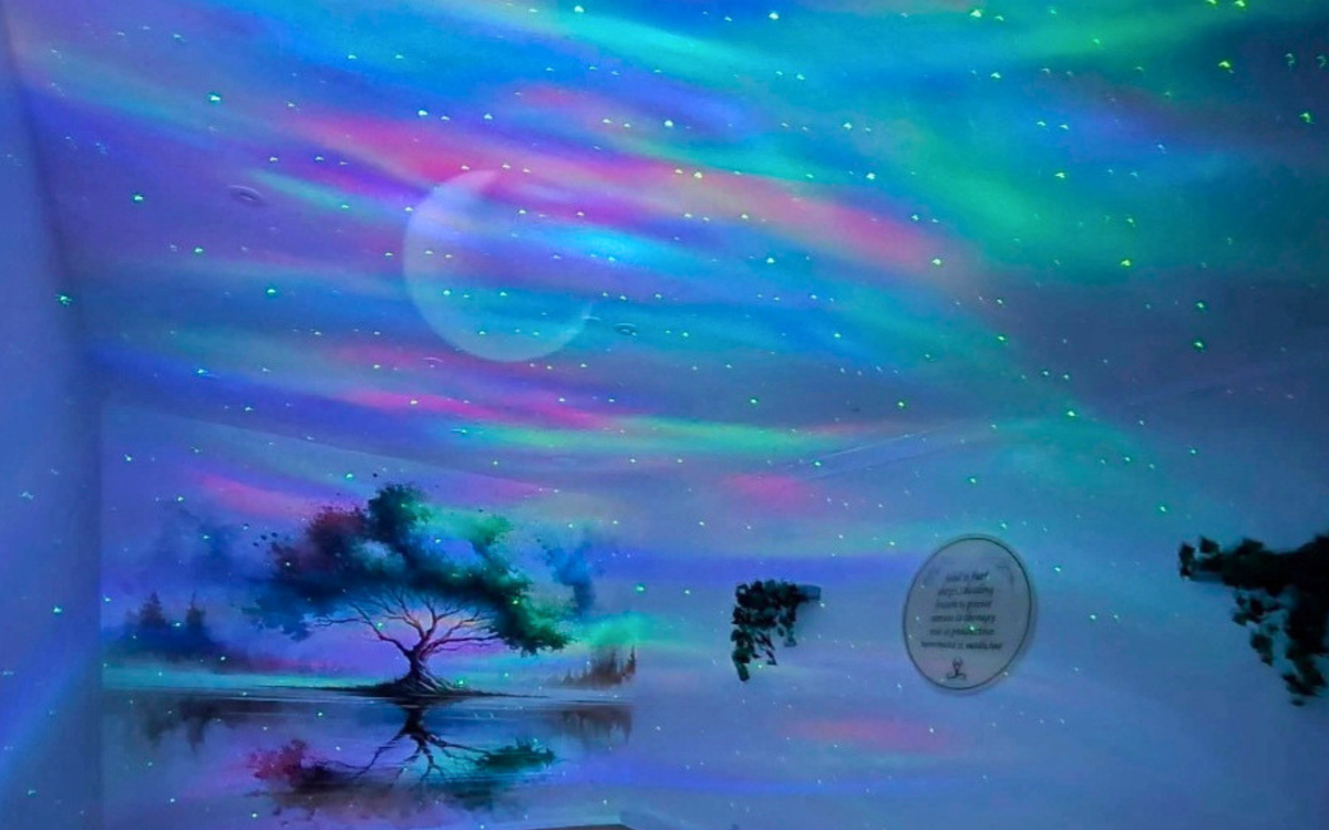 Calming colours and starry skies are projected on the walls of a treatment room.