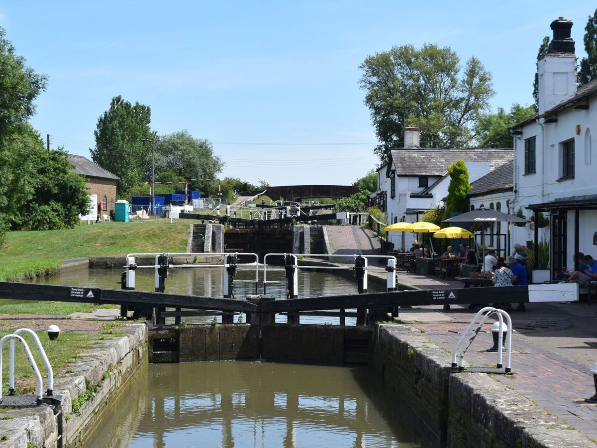 Image or Canal locks, sunny day, café on the side of the canal with people sitting outside 