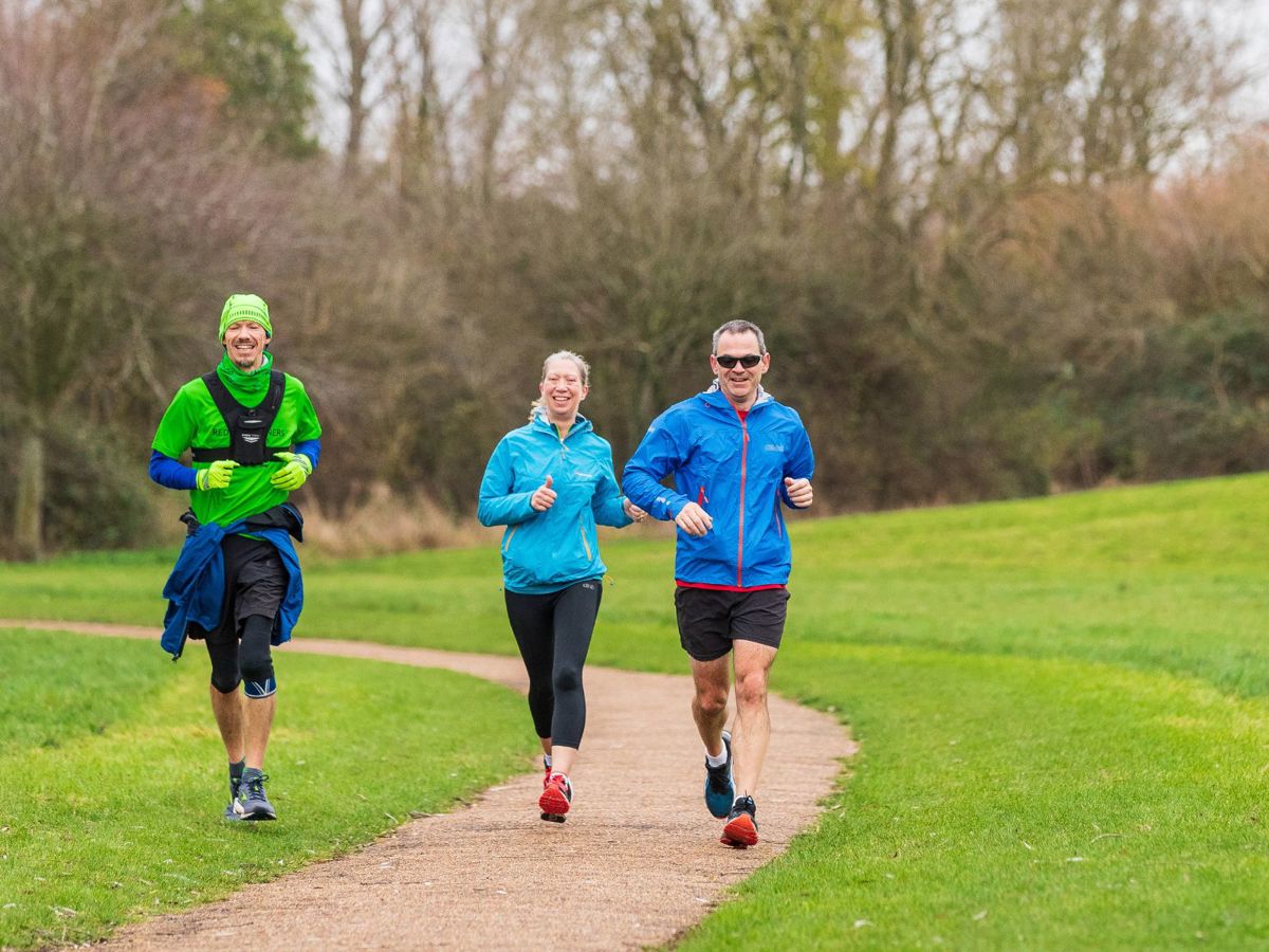 Group of runners going down a path in the park