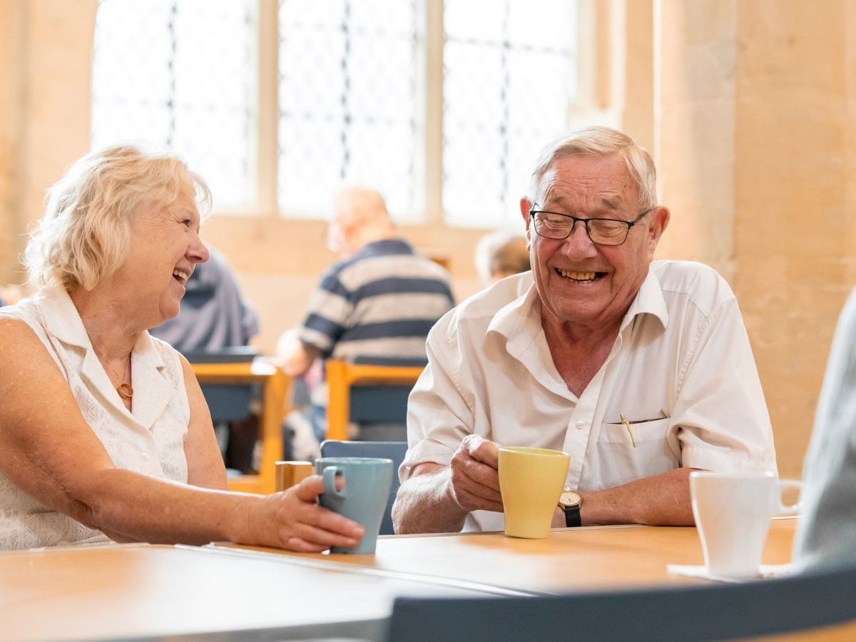 Two people sat drinking coffee inside church