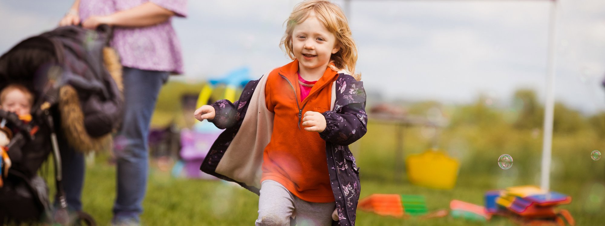 Child running in park with bubbles