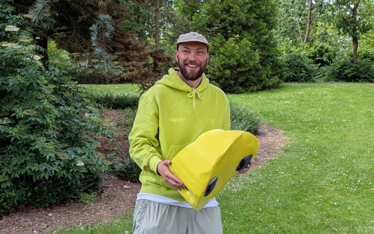 Artist Richard Harrison in park holding public art piece