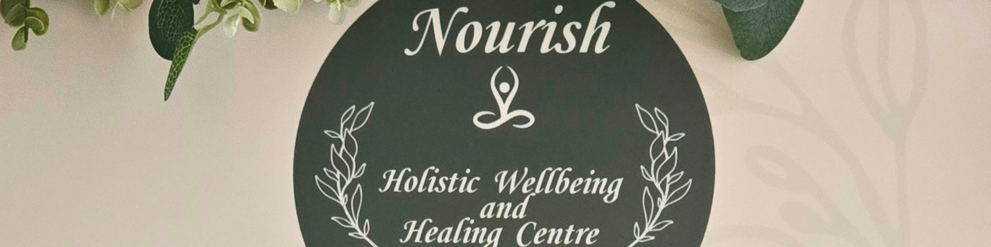 A round sign with the Nourish logo and graphics of calming hands.