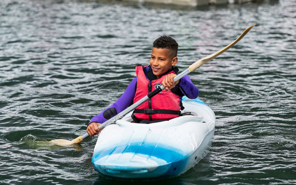 Person kayaking with paddle on Willen Lake in Milton Keynes