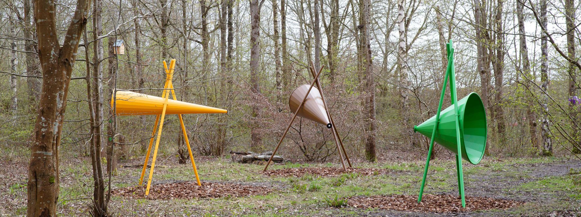 Large yellow, brown and green cones on stands within woodland