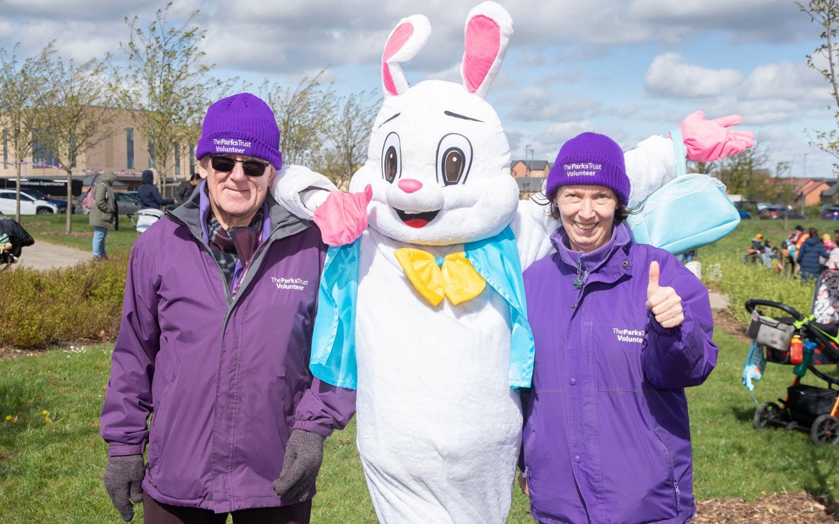 Two volunteers in purple uniform with Easter bunny