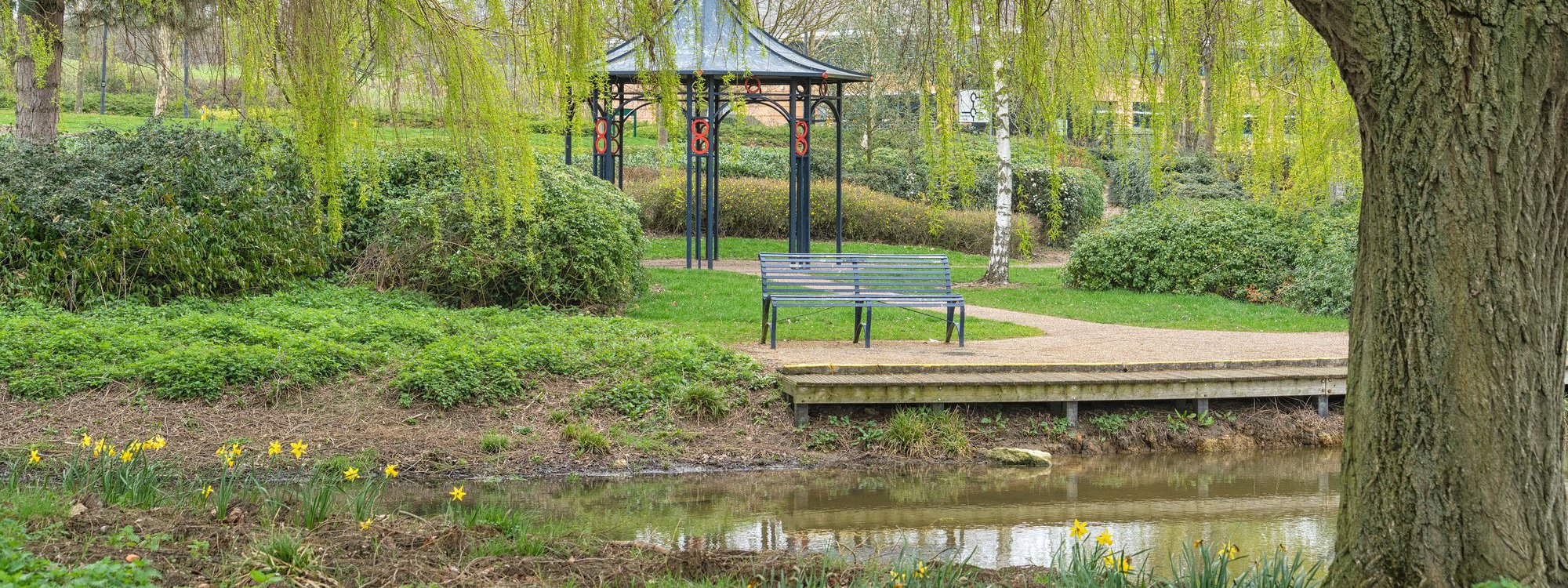 Band stand and bench next to a pond