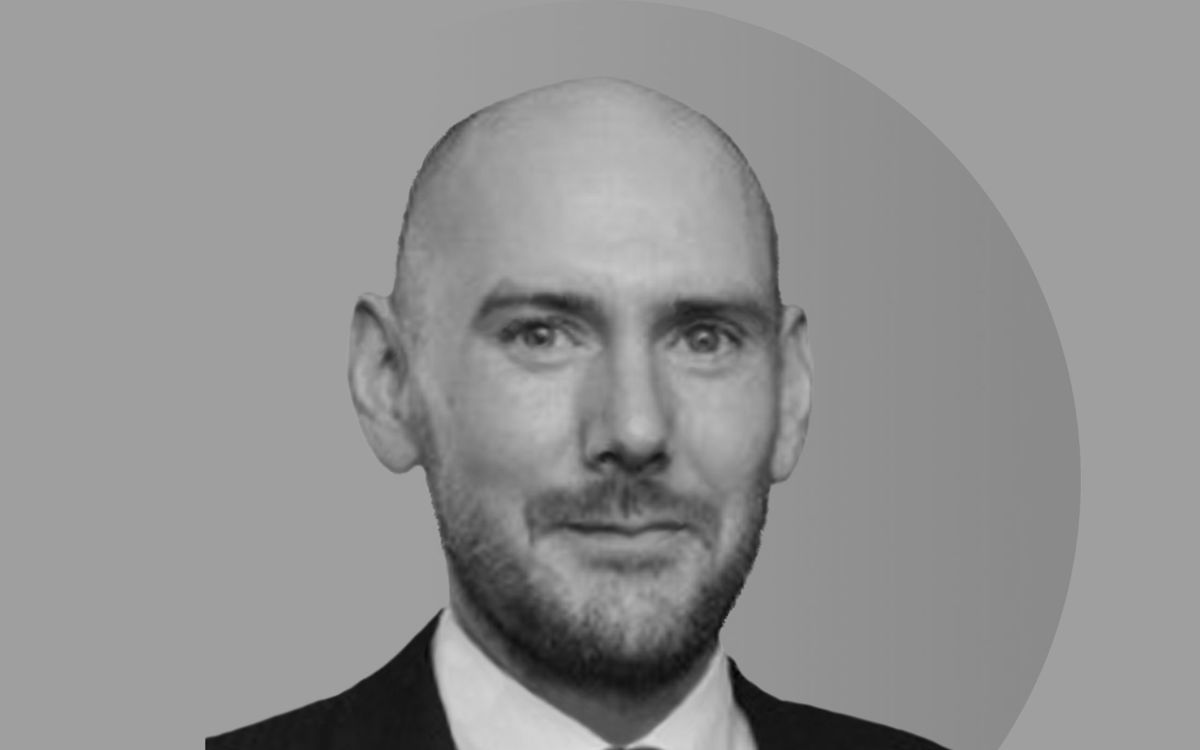 headshot of male in black and white on grey background