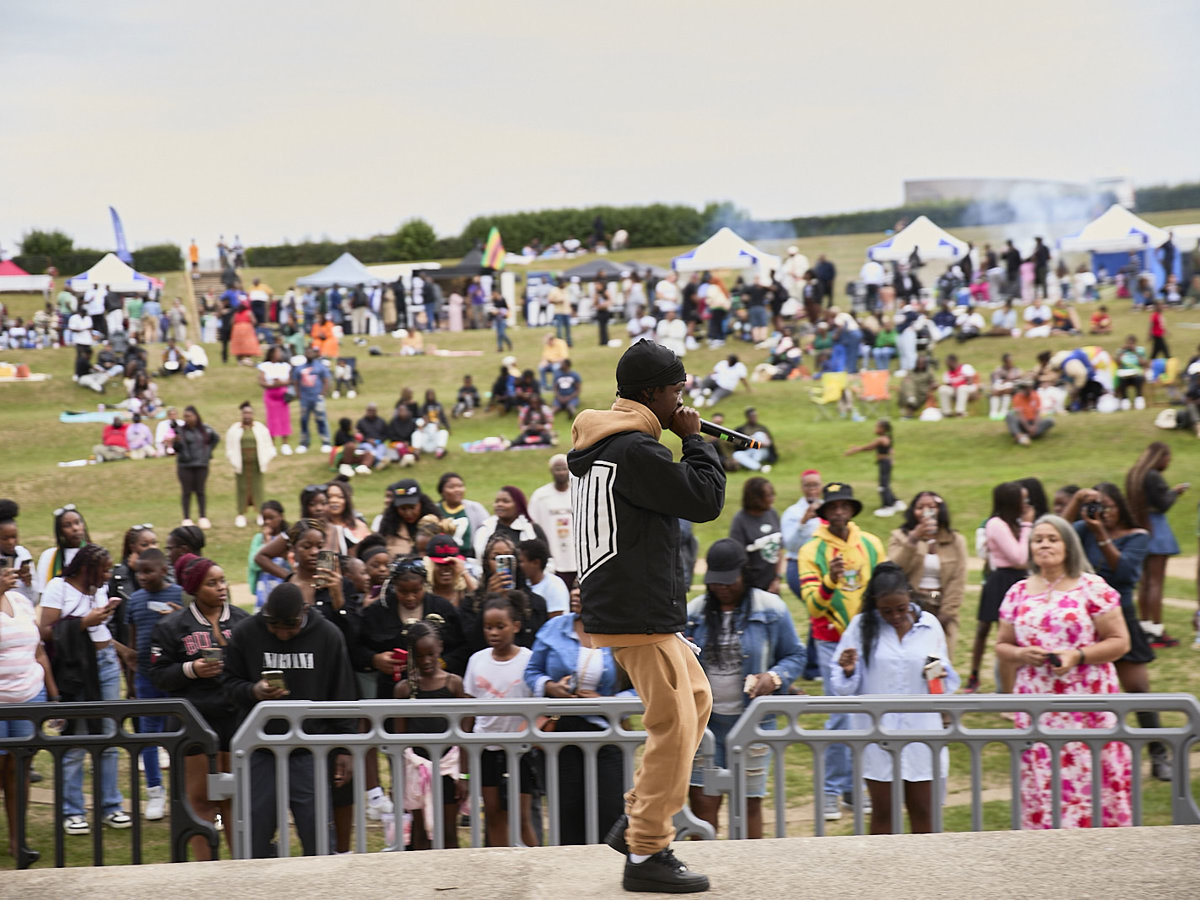 Person performing to audience on stage in Campbell Park