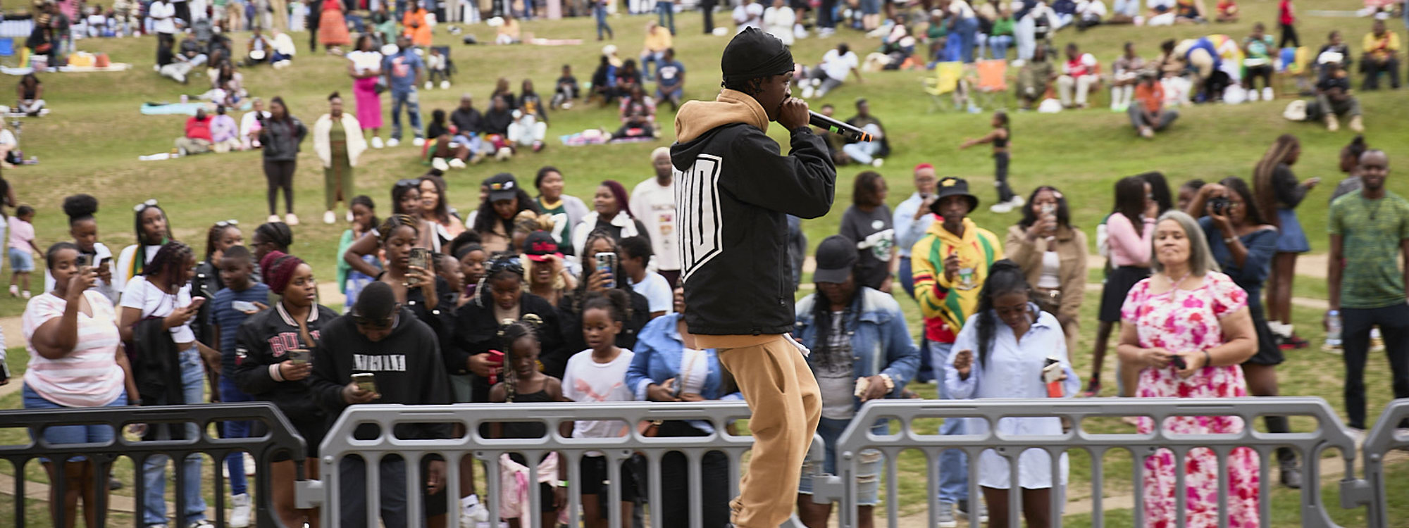Person performing to audience on stage in Campbell Park